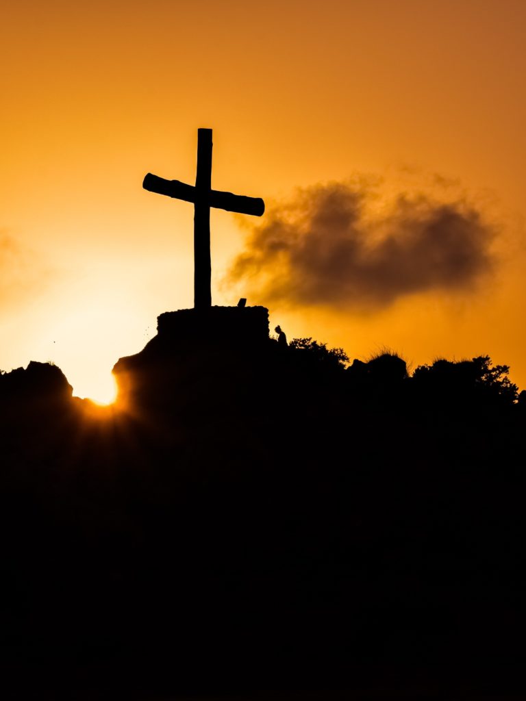 Cross on a hill silhouetted against the sunset